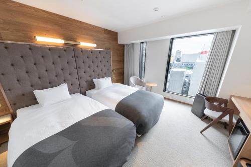 a hotel room with two beds and a large window at The knot Sapporo - Vacation STAY 96529v in Sapporo