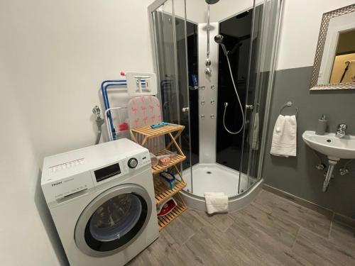 uma máquina de lavar roupa na casa de banho com um chuveiro em UrbanSuites - Modern & Zentral in der City - Dein Zuhause in Stuttgart em Stuttgart