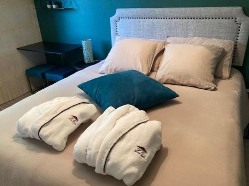 - un lit avec des serviettes et des oreillers dans l'établissement Wine Hôte Chambre d'hôtes, à Le Pian-Médoc
