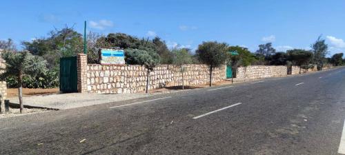 an empty road next to a brick wall at Villa Nature in Toliara
