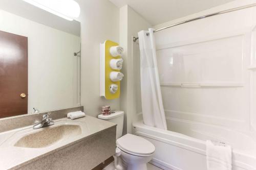 a bathroom with a sink and a toilet and a tub at Motel 6-Lethbridge, AB in Lethbridge