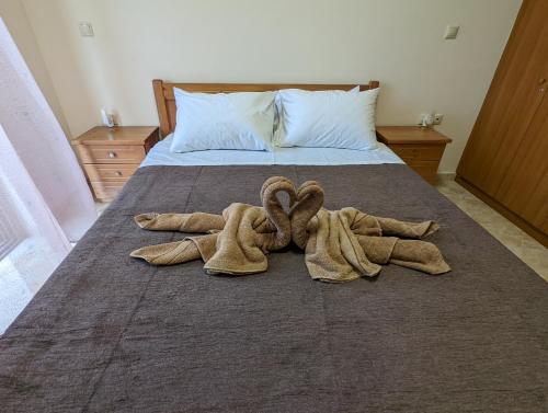 a pair of towels are laying on a bed at Tharenos home in Émbonas
