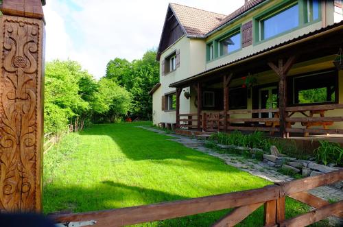 a house with a wooden fence next to a yard at Parkside Vila in Odorheiu Secuiesc