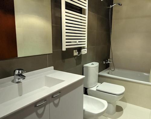 a bathroom with a sink and a toilet and a tub at Apartaments Can Negret in Sitges