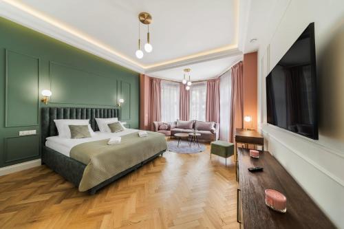um quarto com uma cama, uma televisão e um sofá em H Aparthotel em Ełk