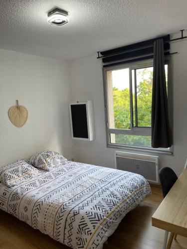 a bedroom with a bed and a window at Les Logis de Paray Appartement 202 in Paray-le-Monial