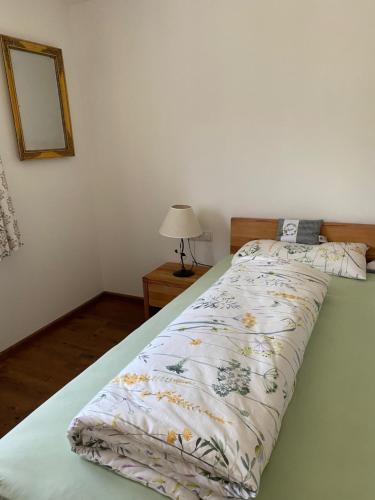 a bed with a comforter on it in a bedroom at Ferienwohnung Alpennestchen Tschagguns in Tschagguns