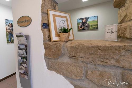 a stone wall with pictures and a plant on it at Sali Homes - GaesteHaus Lamm Obersulm in Obersulm