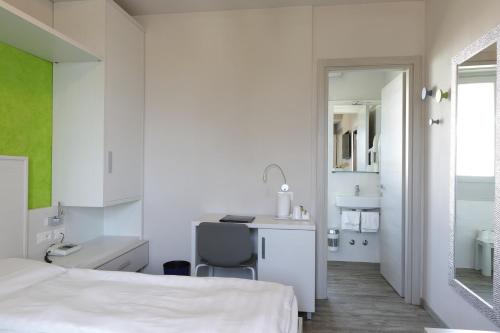 a bedroom with a bed and a desk and a chair at Eco Hotel Benacus in Malcesine