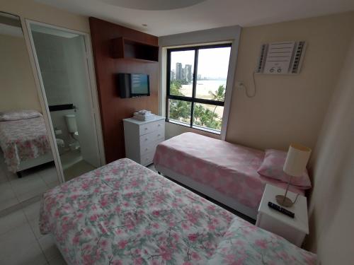 Een bed of bedden in een kamer bij Espetacular Apartamento Beira Mar Pé na Areia