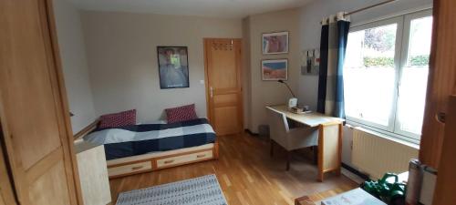 1 dormitorio con cama, escritorio y ventana en 2 Chambres de 16m2 à 10kms de Lille, en Beaucamps-Ligny