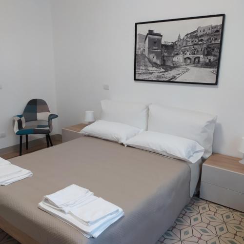a bedroom with a bed with a picture on the wall at Apartments for you 2 in Matera