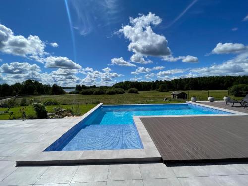 a swimming pool on a patio with a blue sky at Dwa Żurawie - Głuszyn in Głuszyn