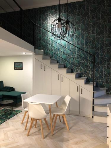 une salle à manger avec une table, des chaises et un escalier dans l'établissement All In Apartman IV., à Budapest