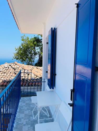 a balcony with a table and a blue door at Άκρη του κόσμου in Samos