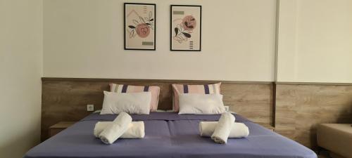 a bedroom with a blue bed with three pillows at G&G Suites in Ohrid