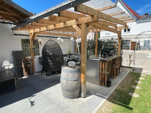 a wooden pergola with a table and a barrel at Sali Homes - Bergerie in Obersulm