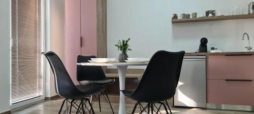 G&G Suites في أوخريد: مطبخ مع طاولة بأربعة كراسي سوداء