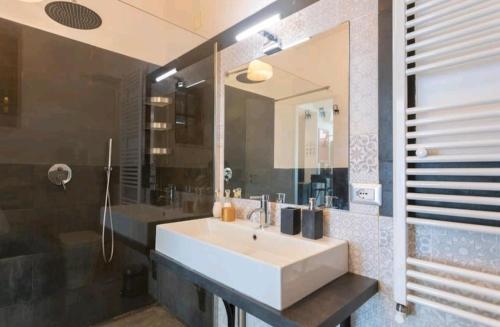 a bathroom with a sink and a large mirror at Villa's apartment on the beach, swimming pool A/C in Palermo