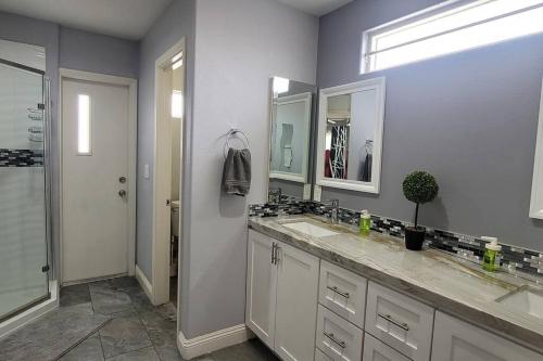 a bathroom with two sinks and two mirrors at K - Fully remodeled and professionally decorated in Las Vegas