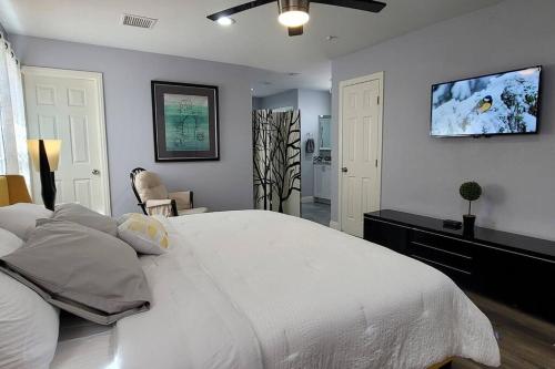 a bedroom with a white bed and a flat screen tv at K - Fully remodeled and professionally decorated in Las Vegas