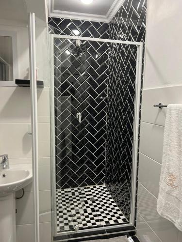 a shower with a glass door in a bathroom at Zindiza Guesthouse in eMalahleni