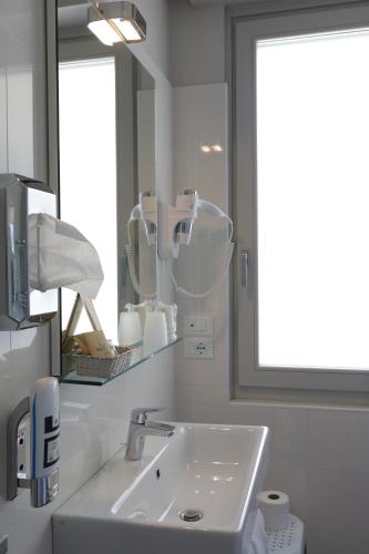 a white bathroom with a sink and a mirror at Eco Hotel Benacus in Malcesine