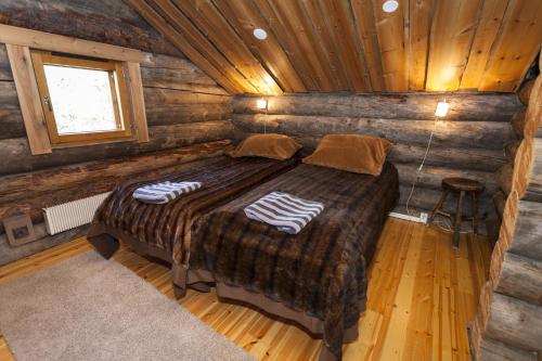 1 dormitorio con 1 cama en una cabaña de madera en LevinPesä Chalet, en Levi