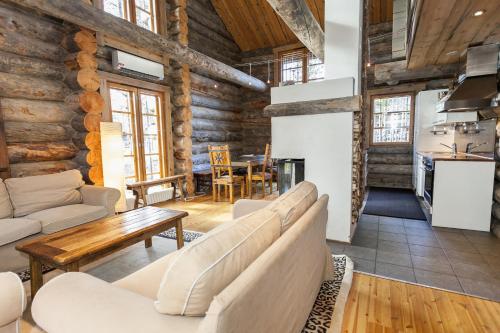 a living room with couches and a table and a kitchen at LevinPesä Chalet in Levi