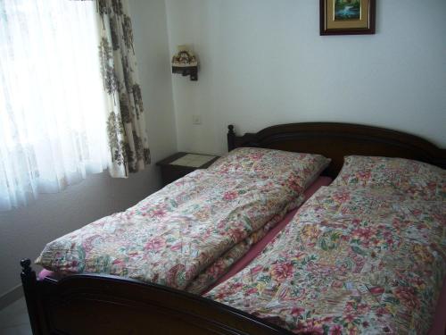 - un lit avec une couverture et une fenêtre dans l'établissement Apartment Foresta, à Saas-Almagell