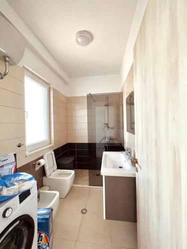 a bathroom with a toilet and a sink at Pine Breeze Apartment Gjiri i Lalezit in Draç