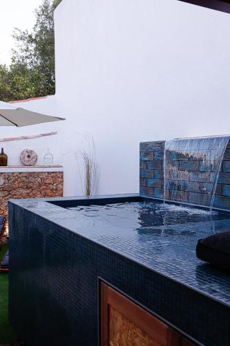 a swimming pool with a water fountain on top of it at Casa Rústica em Alte - KARMEA HOUSES in Alte