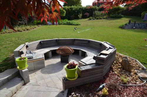 a fire pit with a bench and a grill at B&B Le Bouchat-Oreille in Spontin
