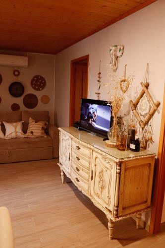 a living room with a tv on a wooden dresser at Casa Rústica em Alte - KARMEA HOUSES in Alte