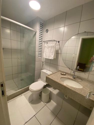a bathroom with a toilet and a sink and a mirror at Barreirinhas Flat Gran Solare 210 in Barreirinhas