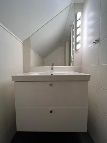 a white bathroom with a sink and a mirror at Villa Bergåsa in Karlskrona