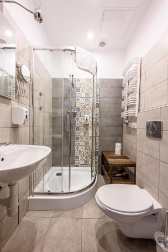 a bathroom with a shower and a toilet and a sink at ON/SET APARTHOTEL in Krakow