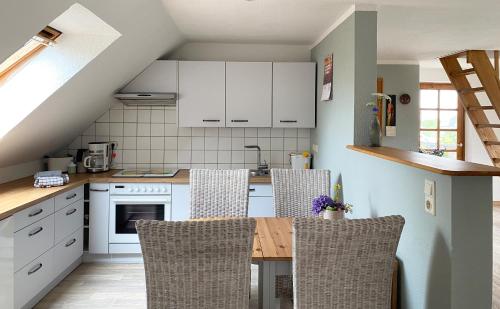 a kitchen with white cabinets and a table and chairs at Auszeit in Hürup
