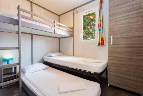 two bunk beds in a room with a window at EAST KEYS - East Cottages in Le Vauclin