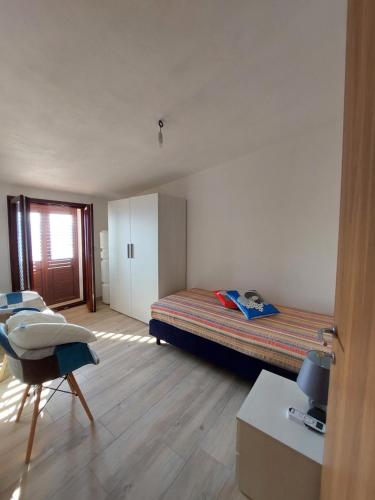 a bedroom with a bed and a chair in it at Attico Panoramico Baunei in Baunei