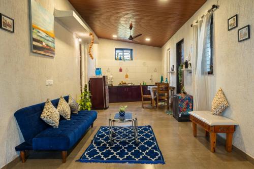 a living room with a blue couch and a table at Nysa Villa Igatpuri in Igatpuri