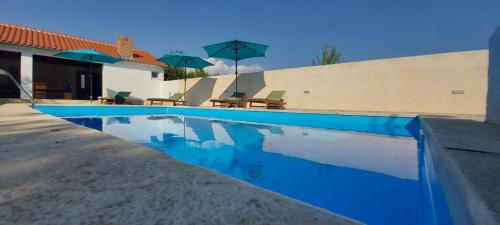 a swimming pool with two chairs and umbrellas at Holiday Home Mary with Pool in Rupalj