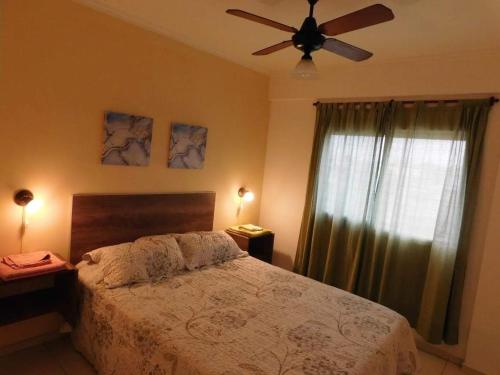 a bedroom with a bed and a ceiling fan at Villasol Temporario in Córdoba
