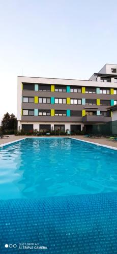 a building with a swimming pool in front of a building at Éden apartman in Balatonföldvár
