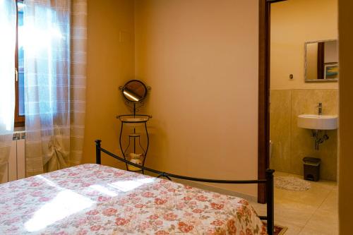 Un dormitorio con una cama, un espejo y un lavabo. en Agriturismo Lodolazzo, en Cortona