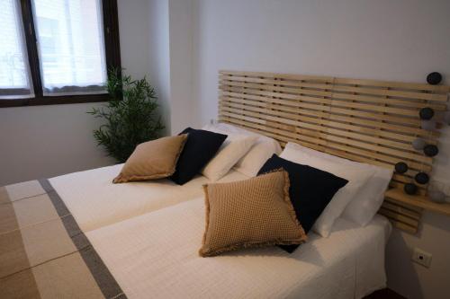 una camera con due letti con cuscini sopra di Apartamento Cabanilles a Villaviciosa