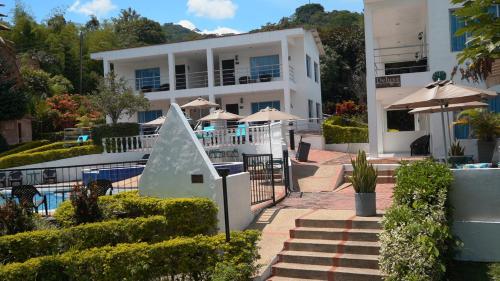 a large white building with a swimming pool at Villeta Boutique Hotel Spa in Villeta