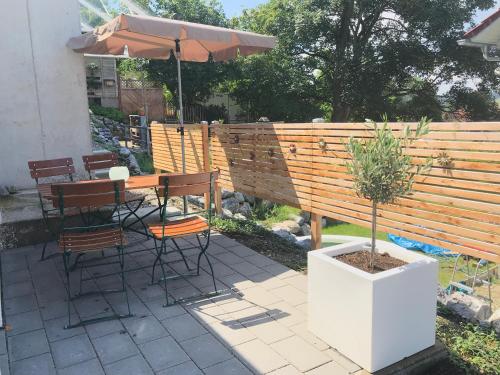a patio with a table and chairs and an umbrella at LÜFTLE neue gemütliche große Familien Ferienwohnung im Allgäu in Wolfegg