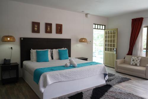 a bedroom with a large bed with blue pillows at Villeta Boutique Hotel Spa in Villeta