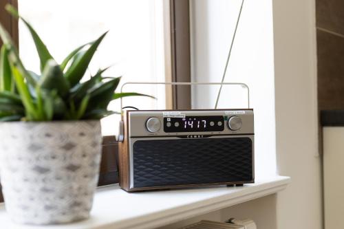 a radio sitting on a shelf next to a plant at Apartments am Neuen Theater - Altstadt - Zentral - Küche - Wifi - Powered by Ko-Living in Halle an der Saale